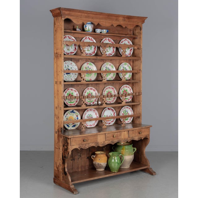 An early 19th century Country French plate rack made of solid cherry and pine. Five shelves with hand-carved rails above a...