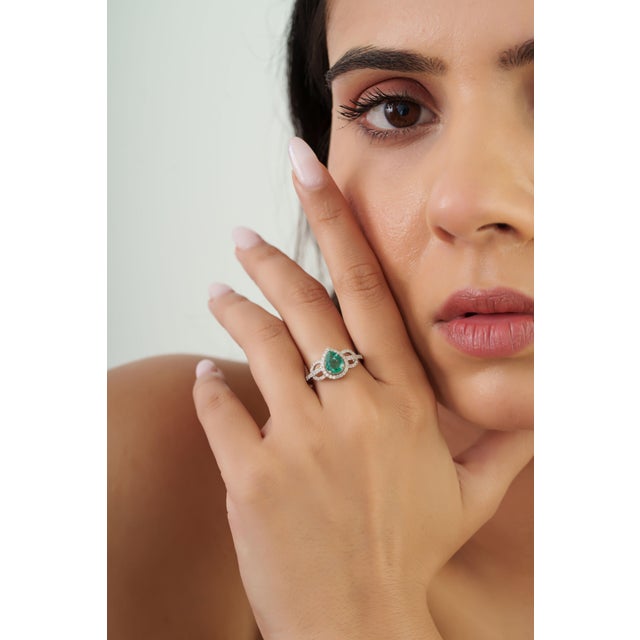 This halo engagement ring showcases a 0.74 carat pear-cut emerald set in 14k white gold. The emerald measuring 7.2 x 5.9...