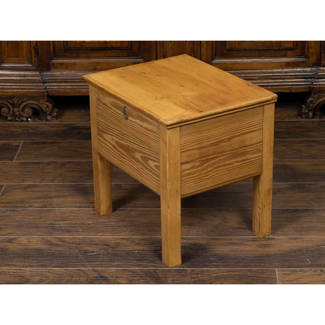 A rustic English pine box on legs from the early 20th century, with brass escutcheon. Created in England during the early...