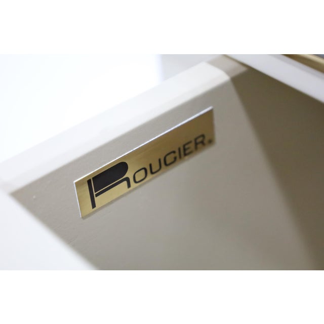 Rarely seen pair of great looking Roger Rougier nightstands in off-white lacquer with gold trim. There are two drawers....