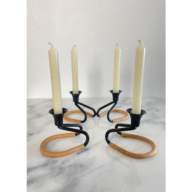 A set of four candlesticks attributed to Walter Bosse. These candelsticks feature curved blackened steel wrapped in a...