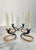 A set of four candlesticks attributed to Walter Bosse. These candelsticks feature curved blackened steel wrapped in a...