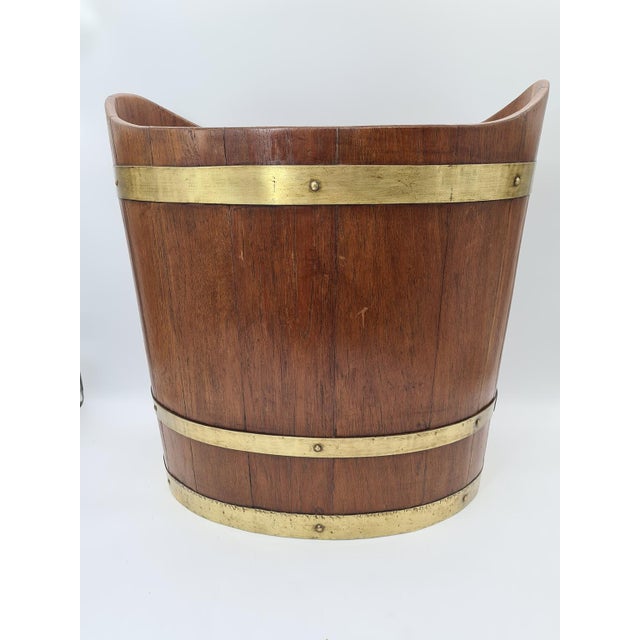 A decorative wooden bucket made using traditional cooperage techniques from solid wood and decorated with hand-riveted...