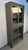 A striking industrial metal cabinet featuring a smooth sliding glass door and a clean, utilitarian silhouette. Combines...