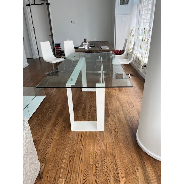 Miles Italian Contemporary glass dining table. It is handmade, with transparent tempered glass with base in chrome with...