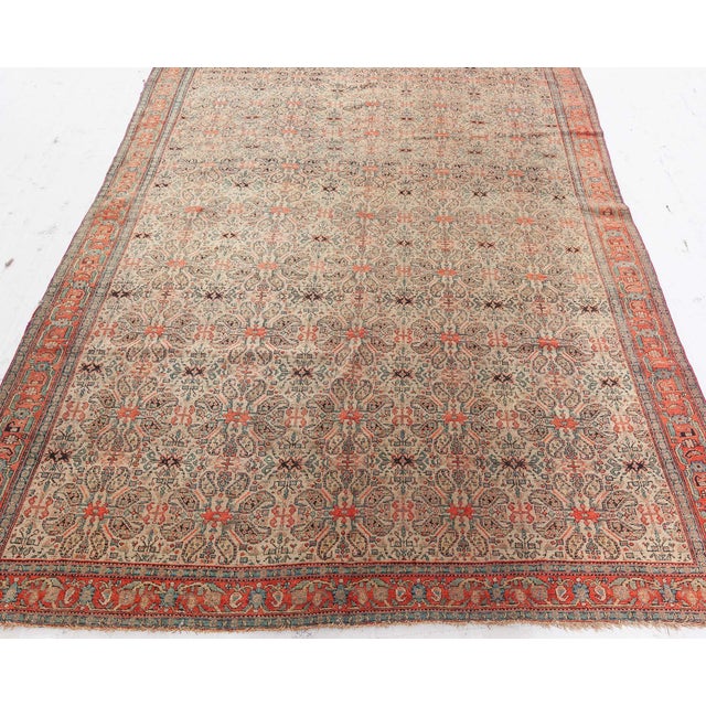 This circa-1880 antique Persian Senneh rug features an all-over design of repeating floral abstractions composed of the...