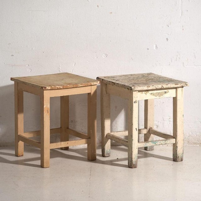 A pair of antique bedside tables in pine wood, with a square top and four tapered legs tied by box stretchers. They...