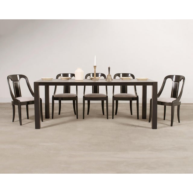 A striking set of eight French Art Deco style dining chairs distinguished by their sculptural gondola sloped-back...
