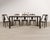 A striking set of eight French Art Deco style dining chairs distinguished by their sculptural gondola sloped-back...