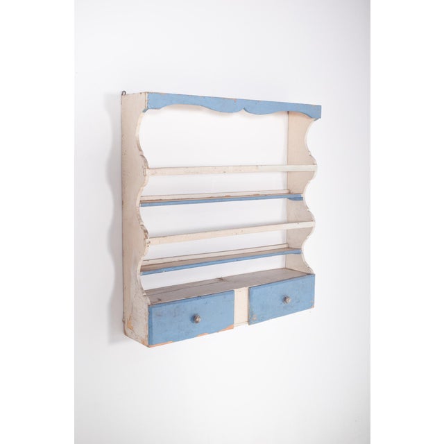 This charming plate rack, painted in white with delicate sky-blue details, combines rustic simplicity with a touch of...