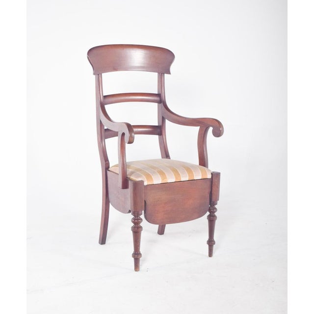 Pencil chair with light striped upholstery. with a backrest on three curved crossbars and gently arched arms, the fabric...