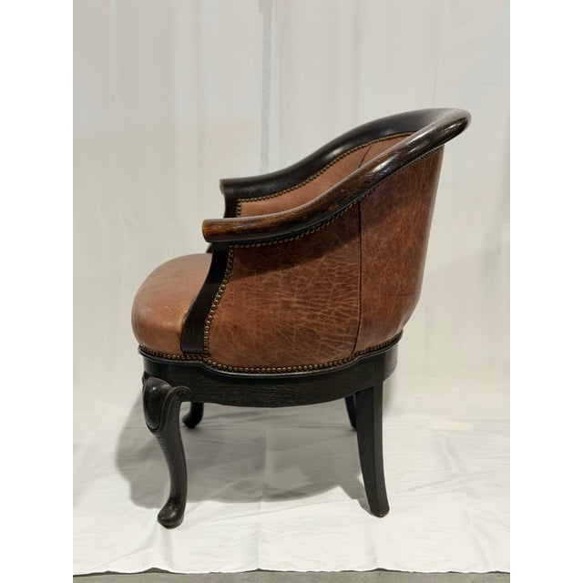 A refined vintage accent chair featuring a gracefully curved barrel back and elegant carved wood frame. Upholstered in...