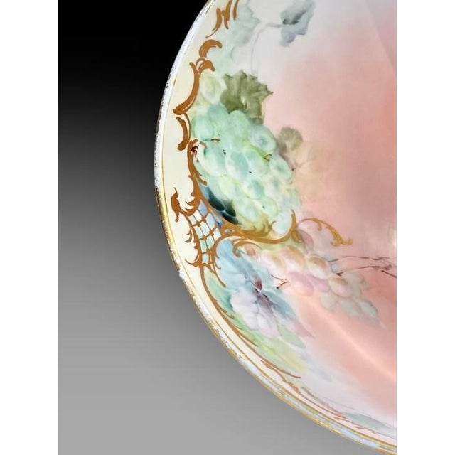 An antique Limoges porcelain punch bowl, produced in France during the late 19th or early 20th century. It features a...