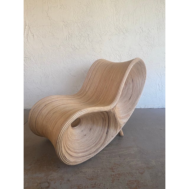 Striking vintage sculptural lounge chair crafted entirely from natural rattan, featuring an extraordinary flowing...