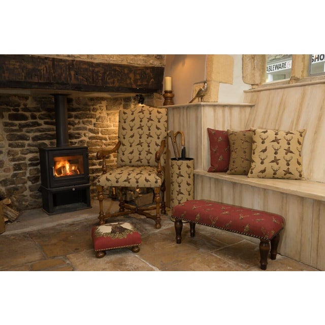 Meticulously handcrafted in the United Kingdom, this upholstered stool boasts classic studding and hand-polished solid...