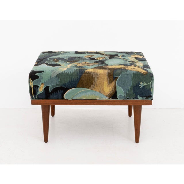 Modern "Doe-Run" Woven Chenille Upholstered Ottoman, on walnut base and four tapered legs. 14" H x 22.75" W x 22.25" D....