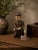 This finely detailed hand-carved Chinese wooden figural sculpture depicts a seated musician holding a small drum, rendered...