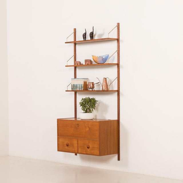 This teak wall unit designed by hansen and guldborg comes from the 1960s and embodies the essence of danish mid-century...