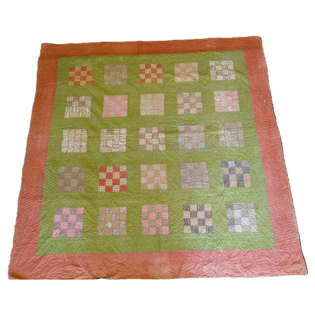 This charming hand-stitched quilt features a patchwork design with varied patterns and colors, predominantly in shades of...