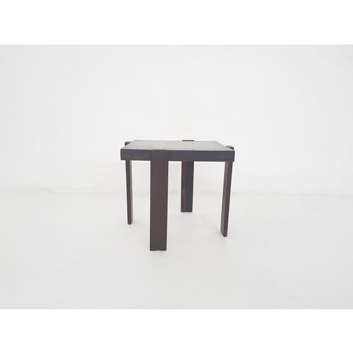 Dark brown solid wooden side table. A light stain on the top.