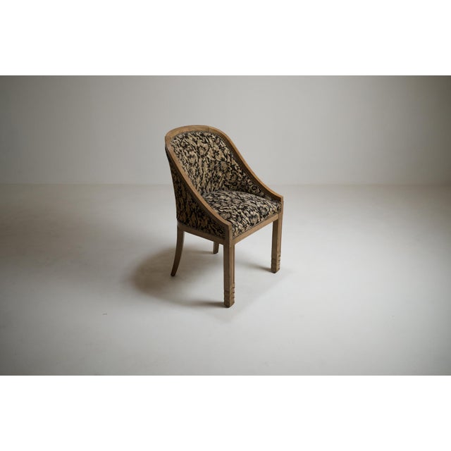 Elegant French Art Deco gondola armchair in oak, dating from the 1930s and preserved in its aged condition. Its enveloping...