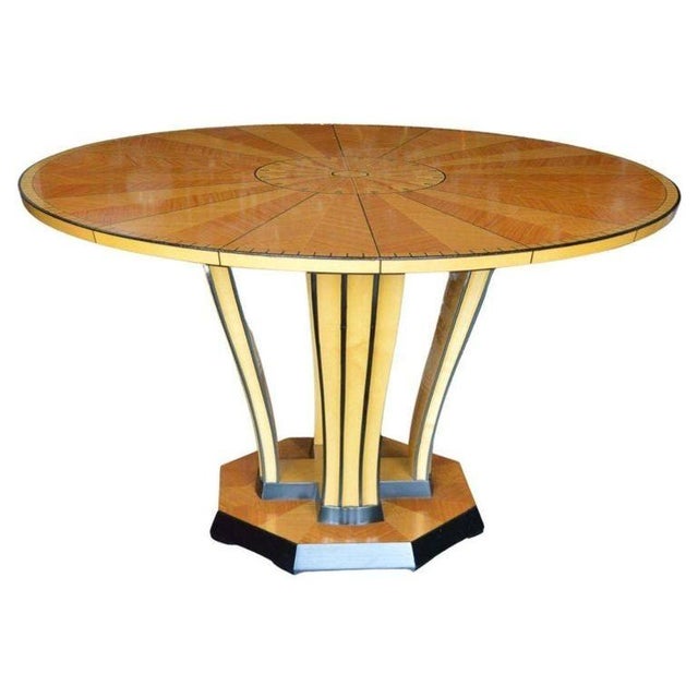 A striking Italian Art Deco round center or dining table, exquisitely handcrafted with a radiating inlaid satinwood...