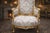 A refined pair of 1970 French Louis XVI–style bergère chairs, crafted in solid beechwood and finished in a warm antique...