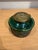 This is a beautiful inkwell made of an iridescent green glass. It has a brass lid with the design of a face, as well as...