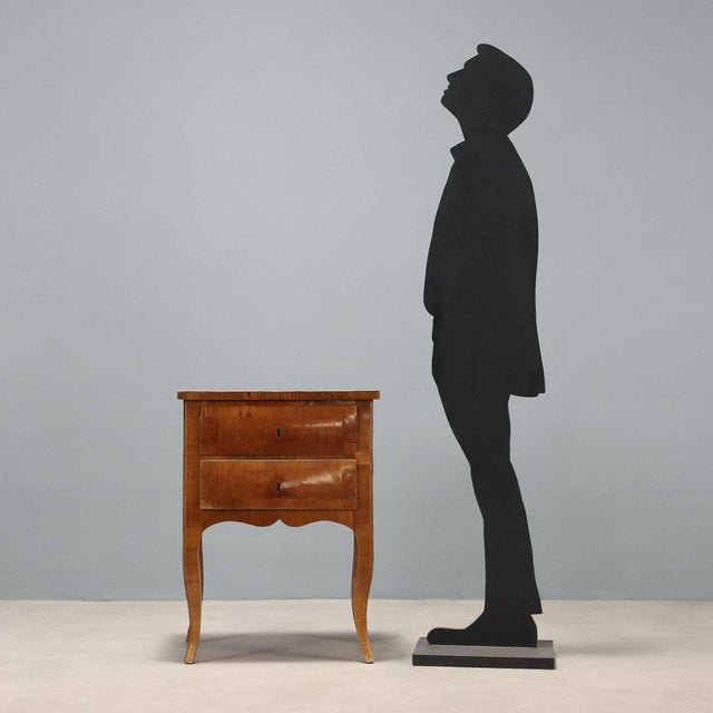 A Baroque walnut bedside table. Rosewood fillets and moldings on the legs and uprights, a two-drawer front, a molded...