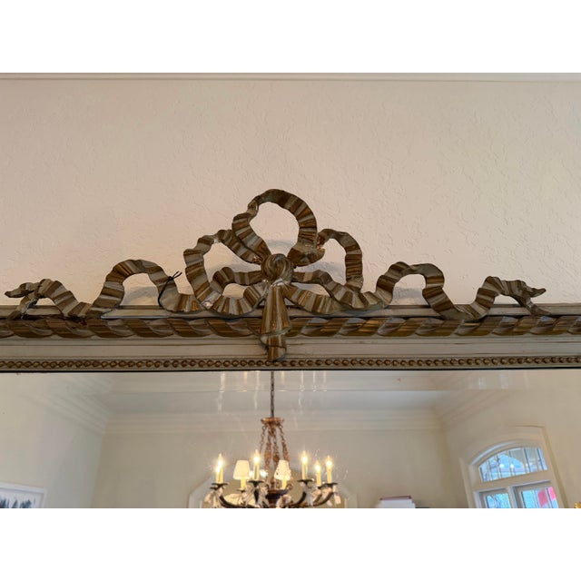 Louis XVI style mirror with beveled glass. Painted gray green wood with antique gilt bronze painted accents.