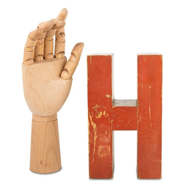 A wooden letter "H" that served as a tool for children at school. The letter is painted yellow on one side and red on the...