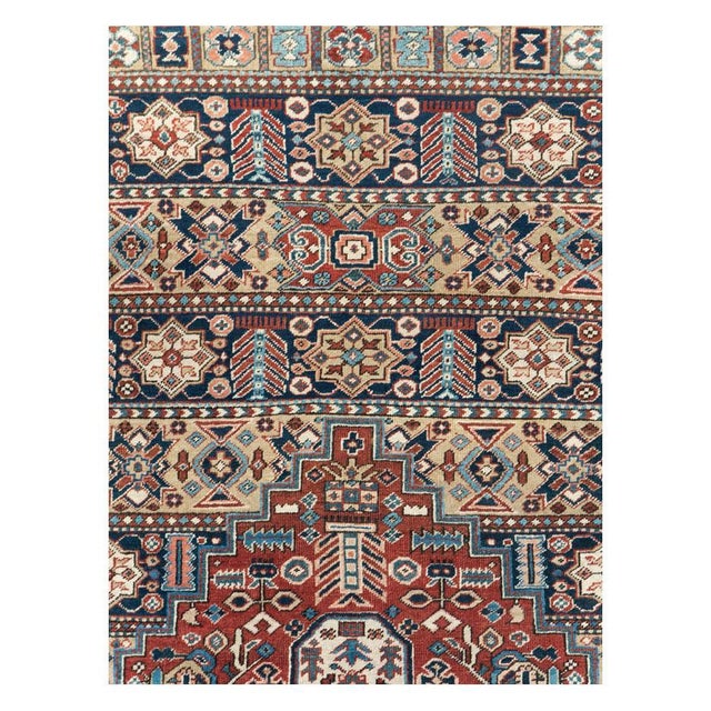 This early 20th-century Persian Heriz room-size carpet presents a bold geometric composition centered by a large stepped...