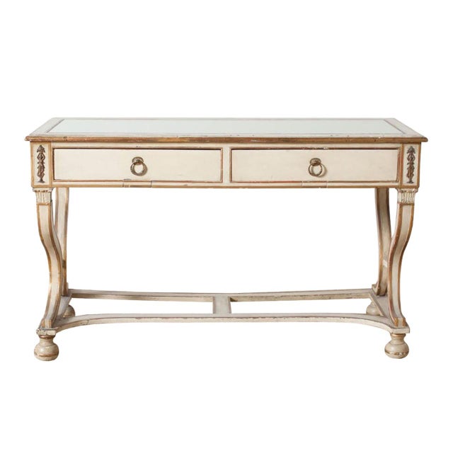 Antique Georgian style console. Two drawers with brass ring pulls. Brass goddess motifs. Inset mirror top and stretched legs.