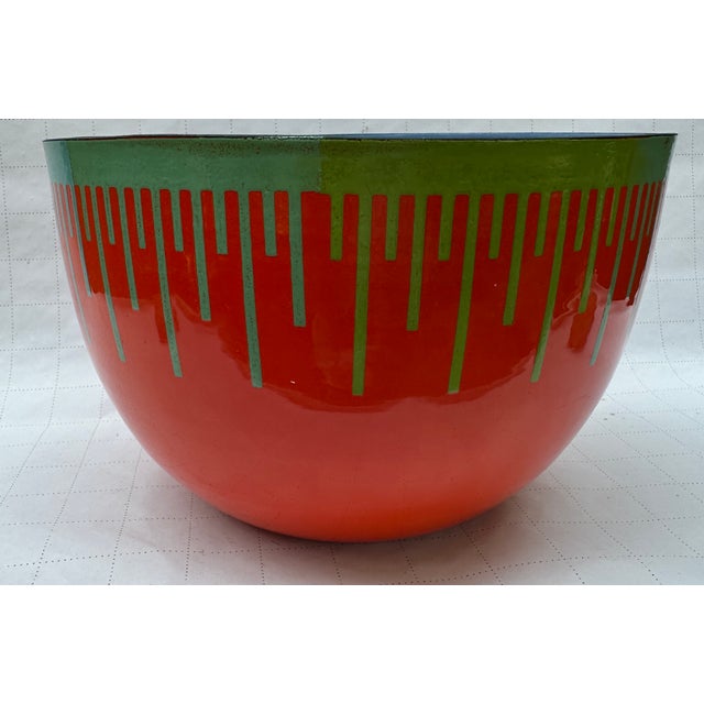 Here we have a super enameled bowl with dropdown lines of different colors around the perimeter , Displayed at the...