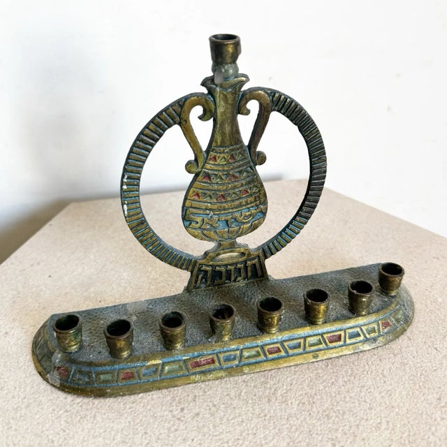 This vintage menorah showcases a timeless design, crafted from brass with intricate hand-painted details. Featuring a...