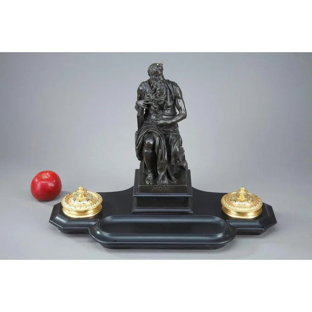 19th century black marble inkwell surmounted by a patinated bronze statue featuring moses by michelangelo. The statue of...