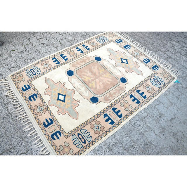 This is a vintage Turkish Oushak rug from the 1960s. The piece was hand-knotted.
