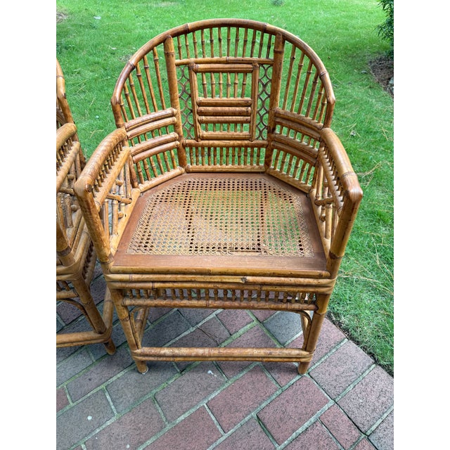 Beautiful pair of mid-century Brighton pavilion bamboo arm chairs with cane seats by Thomasville. Chairs are in a natural...