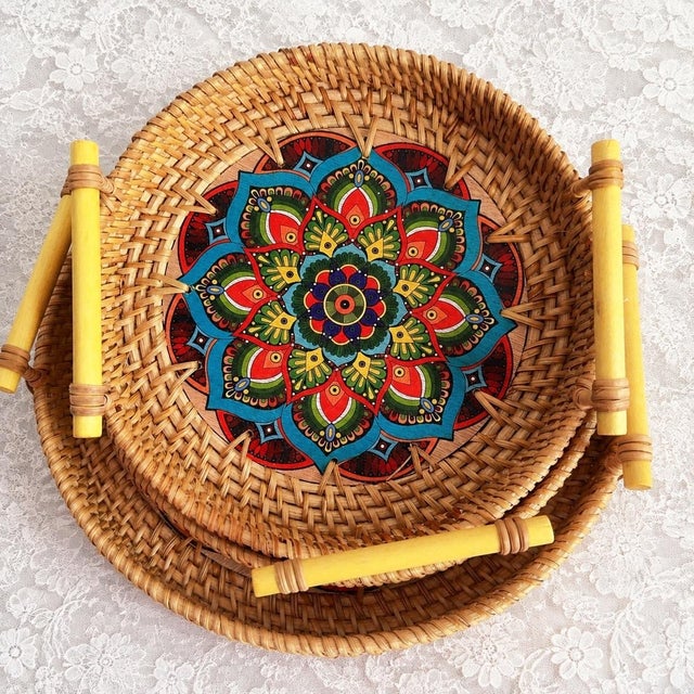 This set of three round trays is hand-woven with rattan and hand-painted mandala patterns by Vietnamese craftsmen. The...
