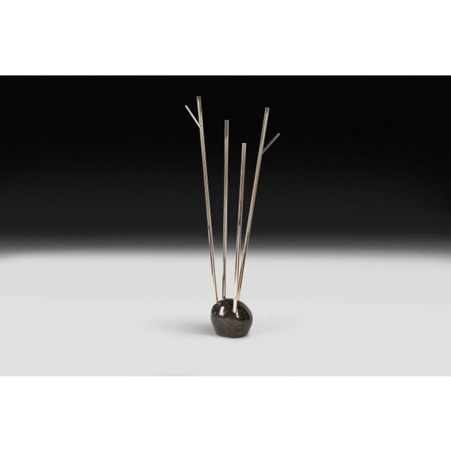 <p>This garment holder features a Pierre Blue Carrara marble base and 24K gold stems. It is from the <em>Unnatural...