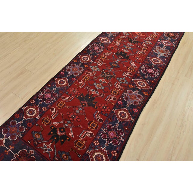 An authentic vintage tribal Hamedan runner hand-knotted with fine wool and natural dyes. This nomadic rug features an all-...