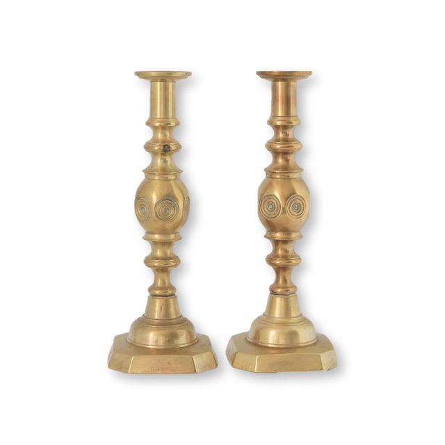 Pair of late Victorian brass candlesticks with bold turned columns and octagonal bases, each stamped "GOOD LUCK" with a...