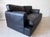 A sofa * a 2-seater sofa * made of black leather * by arcon italia * postmodern design from the 1980s * with geometrically...