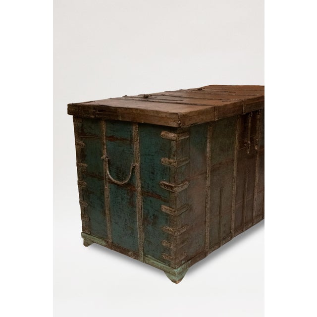 Wooden chest mounted with thick iron banding for strength and decoration; with carrying handles to the sides. With traces...