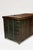Wooden chest mounted with thick iron banding for strength and decoration; with carrying handles to the sides. With traces...
