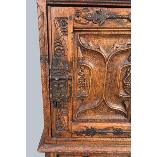 A top quality Carved Gothic Cabinet in the medieval style. Ribbon-fold carving to the sides and lower door. Superb iron...
