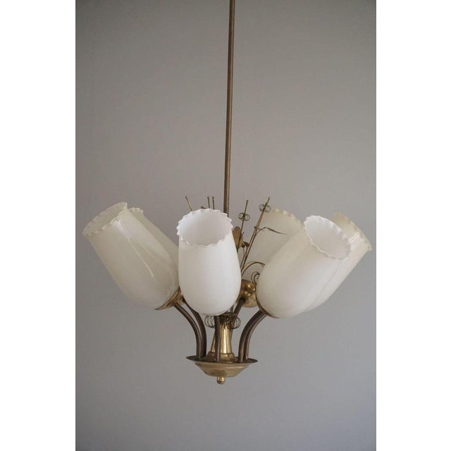 This fantastic 1940s chandelier by paavo tynell, designed for idman oy, is a masterful blend of elegance and whimsy....