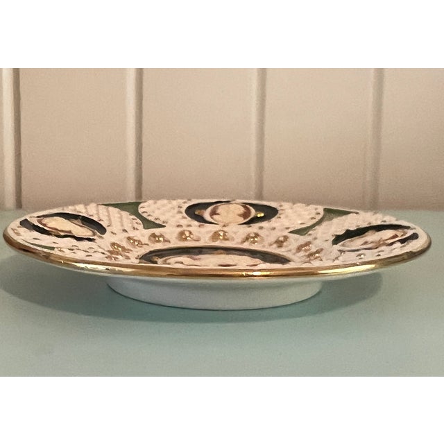 A striking vintage decorative plate featuring five raised cameo-style portrait medallions each depicting classical figures...