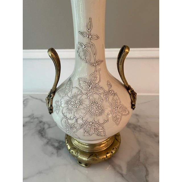 This oriental style lamp has a very modern feel with its tone on tone colors of white and gray. Brass handles and base...