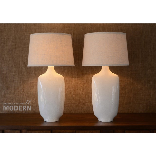 Amazing pair of mid century modern white ceramic table lamps with a crackle finish. Stunningly sculptural in form with a...